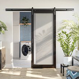 1 lite black frame barn door leading to a laundry room with plants